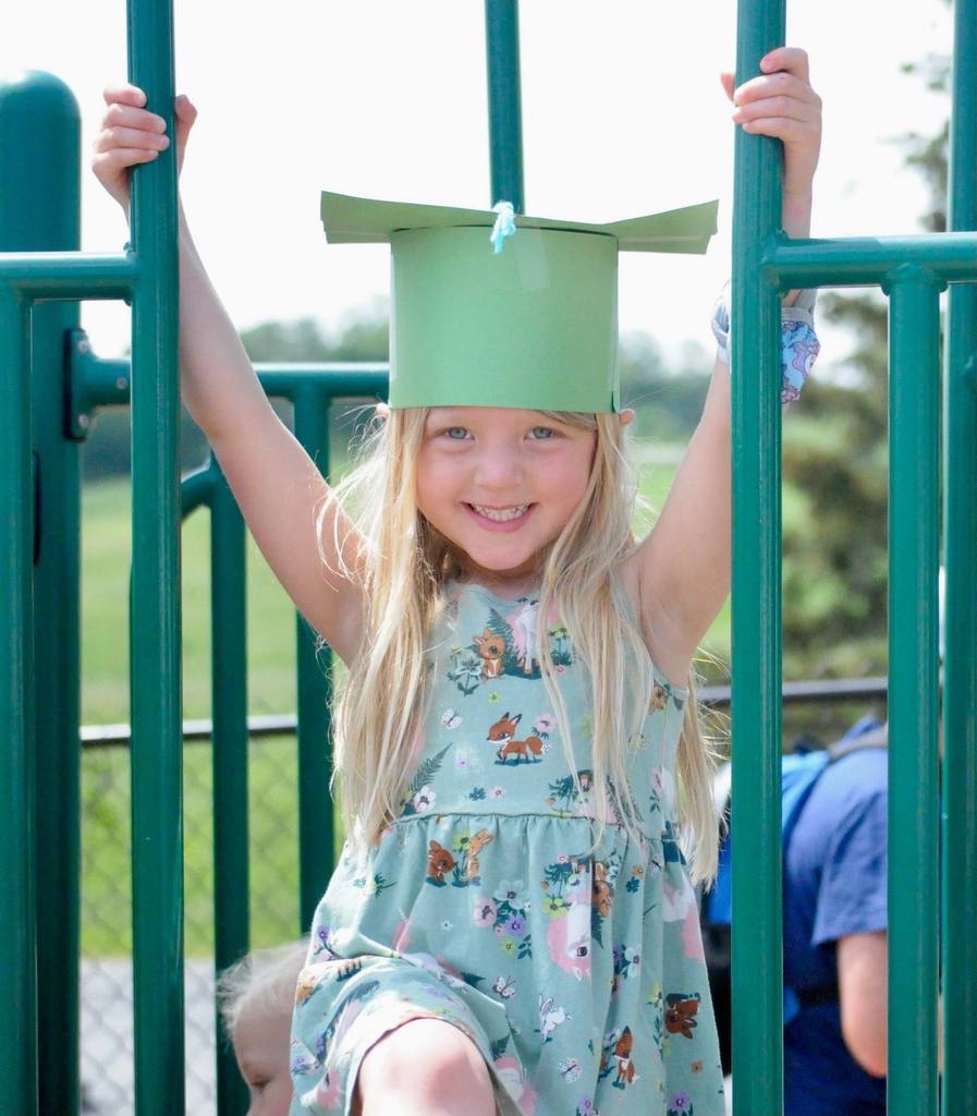 rutland student on playground with paper graduation hat
